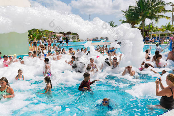 快乐微笑的快乐的人们放松和享受他们的时间在游泳池泡沫党的伟大邀请美景