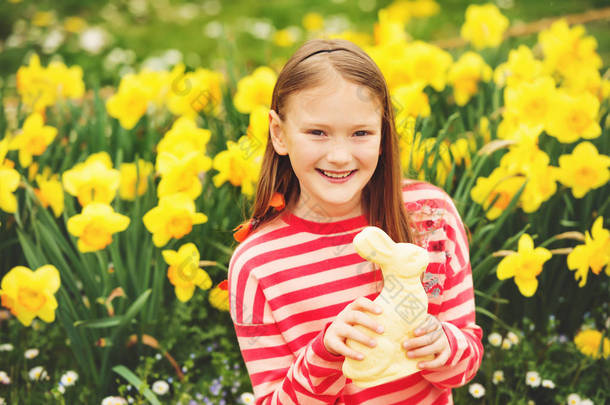 可爱的孩子的小姑娘与白巧克力复活节兔子庆祝<strong>传统节日</strong>。家庭，假期，春天，无忧无虑的童年概念.
