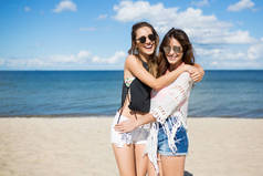 年轻漂亮的女人，互相拥抱在海滩上