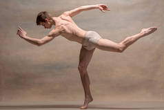 在灰色的背景构成的男芭蕾舞者