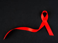 世界援助日的概念。黑色背景的红丝带.