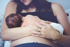 年轻妈妈母乳喂养她的孩子，抱着他在她的胳膊和 s