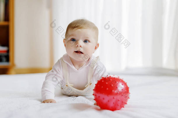 可爱的婴儿玩红胶球，爬行，抓取