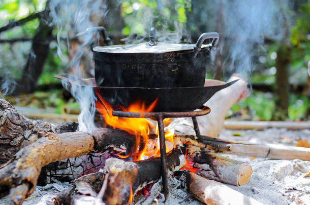 用旧的黑<strong>蒸煮</strong>锅和烟雾在壁炉里燃烧木柴