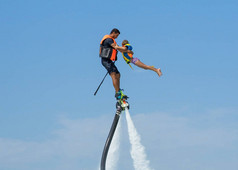 父亲和他的女儿在加勒比热带海滩的新 flyboard 的姿势。积极的人的情感, 感觉, 喜悦。逗人喜爱的孩子做假期和享受夏天.