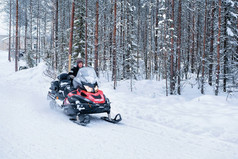 罗瓦涅米芬兰冬季森林骑雪地车的妇女