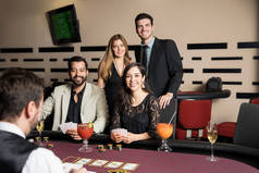 有吸引力的一群拉美朋友打牌在赌场扑克表