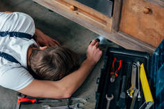 年轻修理工用手电筒检查烤箱的高角度视角