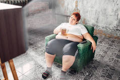 超重妇女坐在扶手椅和喝啤酒, 症, 肥胖和不健康的生活方式概念