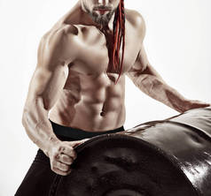 健身男子与完美的身体做练习铁桶