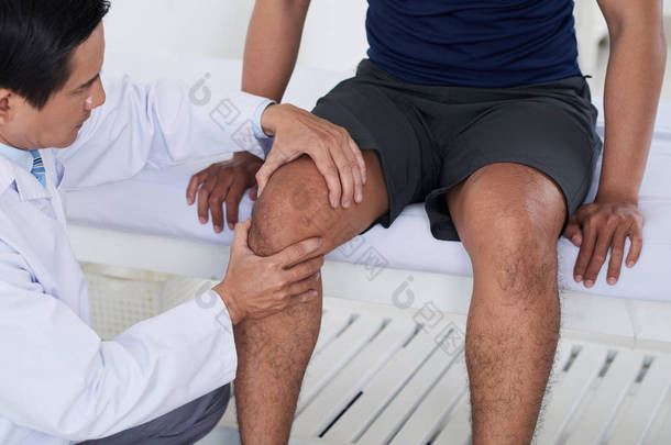 医生检查男性运动员膝关节
