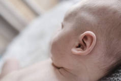小婴儿的耳朵在床上, 特写。新生儿小耳的细节.