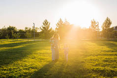 母亲, 小女儿和小儿子漫步在夏日阳光公园