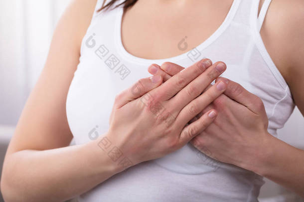 女性的手在乳房遭受痛苦的特写