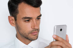 美丽的特写照片的年轻人使用手机灰色背景。商人用他的智能手机讲话。裁剪面.
