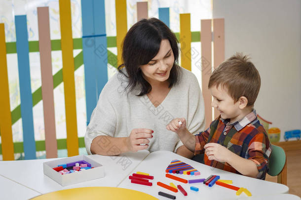 母亲, 老师, babisitter 教孩子。表上是彩色对象。幼儿园概念学习.