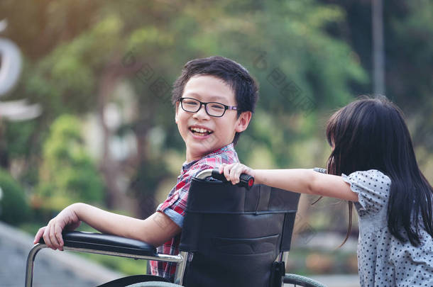 快乐男孩在轮椅与女孩尝<strong>试驾</strong>驶她的轮椅