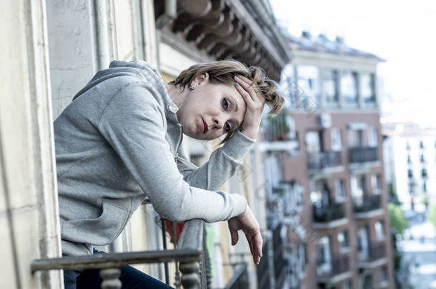 年轻有魅力的白种女人带着忧郁和焦虑的心情在家里的阳台上感到悲惨和无望。城市背景。<strong>心理健康</strong>与抑郁症概念