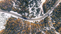 冬季森林中山上一条曲线上的汽车鸟瞰图.