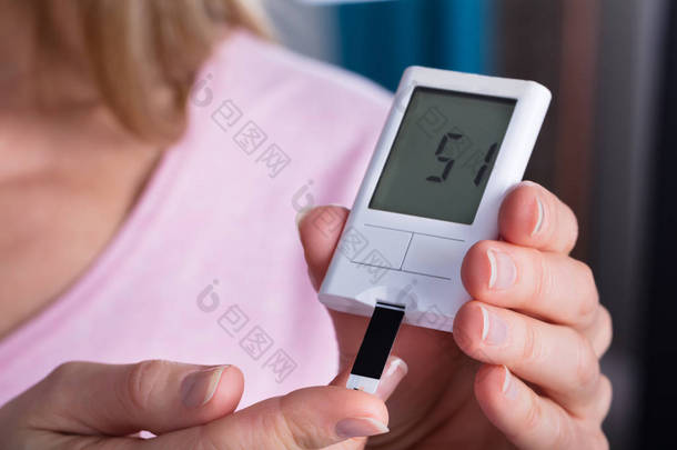 女人的手用血糖仪测试高血糖