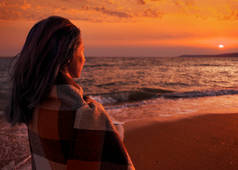 海滩上欣赏日落美景的妇女.