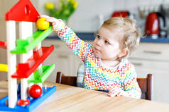 可爱可爱的小女婴在家里或托儿所玩益智玩具.