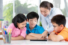亚洲教师与三儿童使用数码片娱乐自己的亲密关系