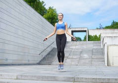 年轻, 适合和运动的女孩跳跳绳跳绳。健身、运动、城市慢跑和健康生活方式概念.