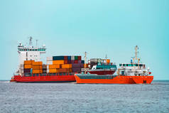 橙色货船移动通过红色容器船在波罗的海