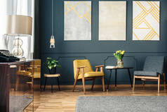 舒适的起居室内有扶手椅、地板上的地毯、桌子上的花、植物和墙上的画。