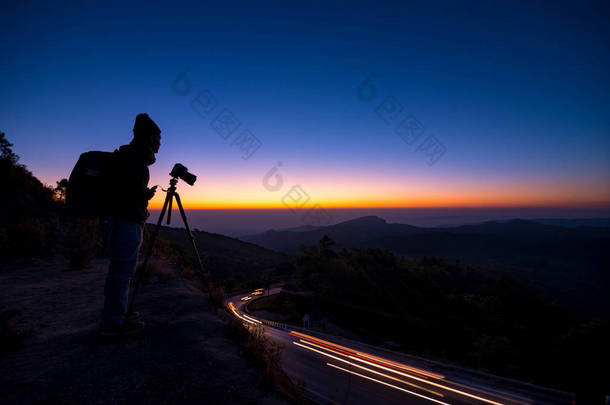 剪影专业摄影师与照相机采取风景<strong>相片</strong>在黄昏日出