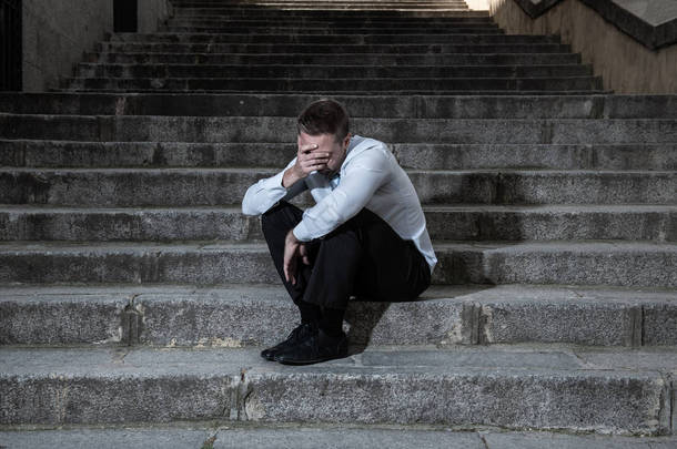 年轻的商人哭着放弃<strong>失落</strong>在忧郁中坐在街头的楼梯上痛苦的情绪痛苦, 悲伤的精神健康概念照片