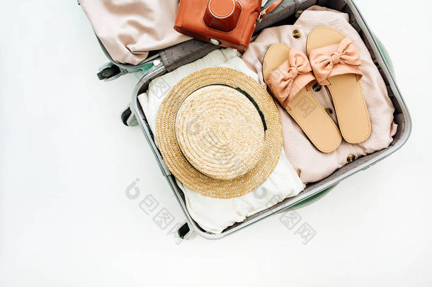 随身携带<strong>时尚女</strong>性服装和复古相机在白色背景的手提行李。平躺, 顶部视图。夏季时尚旅游理念.