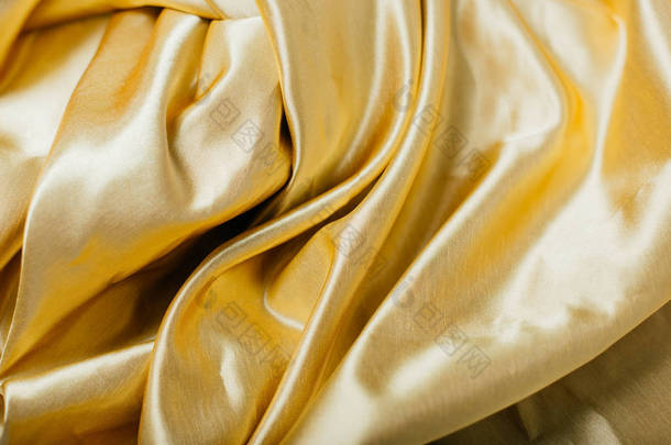 在褶皱<strong>的</strong>金色织物。帷幔。在丝绸上<strong>闪闪发亮</strong>。缝纫