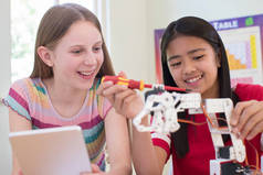 两名女学生在科学课上学习机器人学