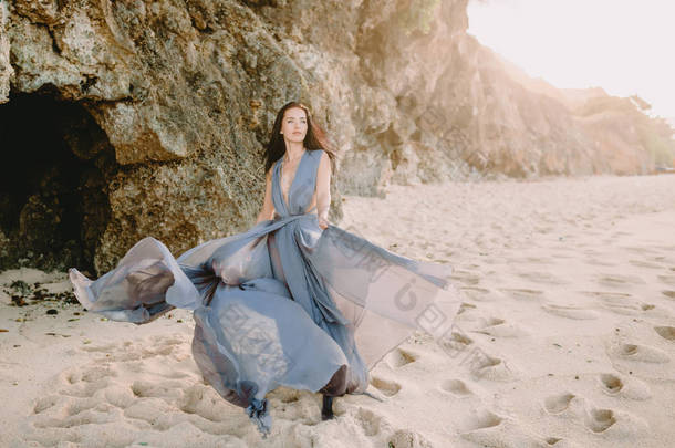 新娘的肖像在<strong>蓝色婚礼</strong>礼服在海滩以日落或日出颜色.