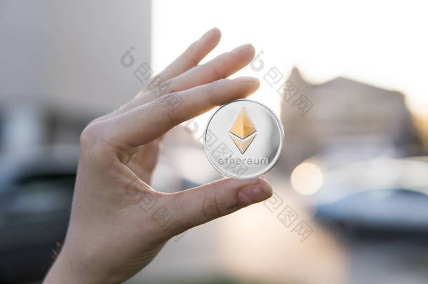 金色银虚灵议会硬币在一个模糊的日落背景手。手持加密货币的虚拟货币。商务, 商业, 交换, 数字货币.