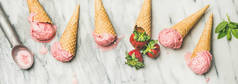 自制酸奶冰淇淋与草莓在华夫饼锥灰色大理石背景