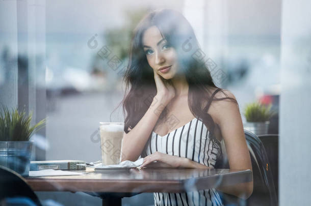 美丽的年轻黑发妇女在条纹黑白相间的礼服<strong>肖像</strong>。在咖啡馆里喝咖啡和<strong>看书</strong>的卷发女人