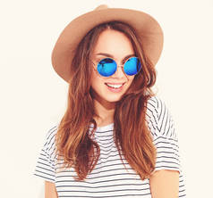 年轻时尚的笑女孩的肖像在休闲夏季衣服在白色背景下的棕色帽子孤立的模型