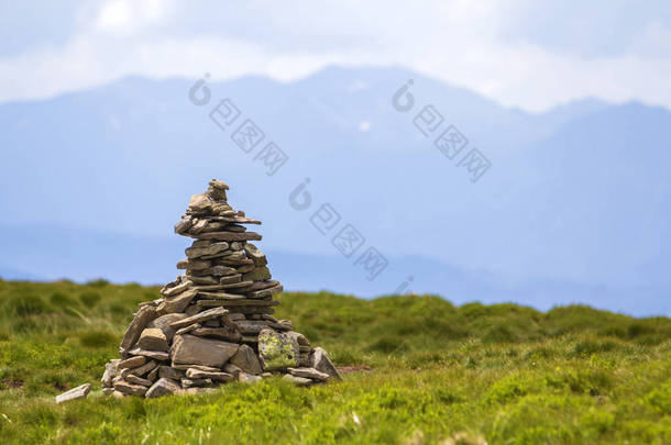 明亮的<strong>夏日</strong>阳光照亮了不平坦的山石堆积和平衡像金字塔堆在绿色的草地上的山谷上的浅白色蓝拷贝空间的天空背景。<strong>旅游</strong>。<strong>旅游</strong>与地标概念.