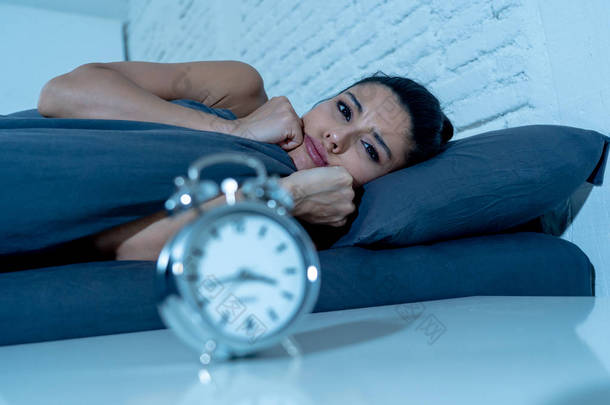 年轻漂亮的西班牙裔妇女在家里的卧室躺在床上深夜试图入睡失眠睡眠障碍或害怕恶<strong>梦</strong>看悲伤担心心理健康概念