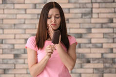 敏感牙齿和冷冰淇淋的年轻妇女在模糊的背景