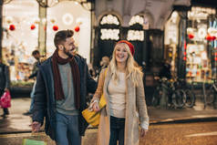在圣诞节购物后, 一对中年夫妇在城市街道上漫步的前景色.