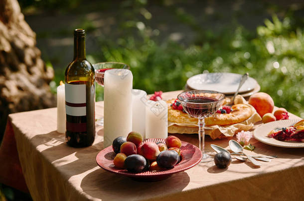 花园桌上的蜡烛、美酒和美味水果