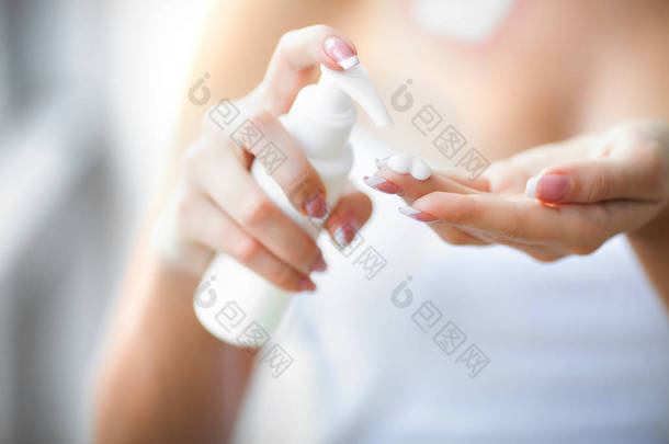 手皮肤<strong>护理</strong>。关闭女性手拿着奶油管, 美丽的女人手用天然指甲指甲在柔软柔滑的健康<strong>肌肤</strong>上应用化妆手霜.