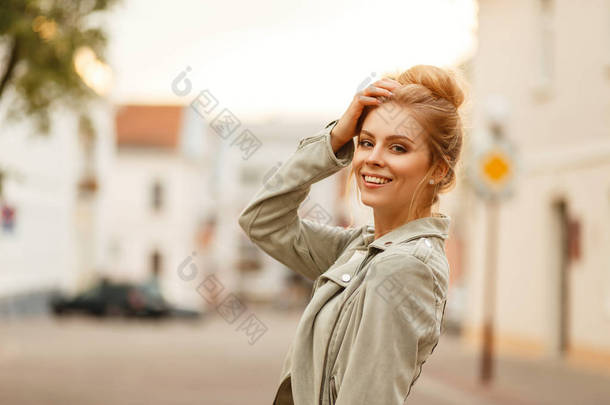 时尚美丽的年轻女子微笑着在时尚的秋季夹克在城市