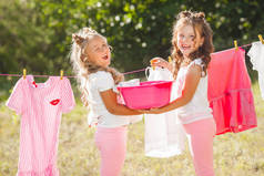 两个小女孩在洗衣店里闲逛。做家务的姐妹