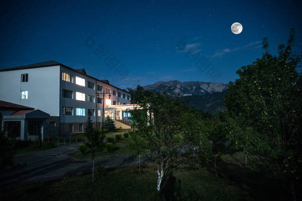 晚上在森林里建筑的山夜<strong>风景</strong>与月亮或老式乡下房子在晚上与云彩和星。<strong>夏日</strong>之夜。照片拍摄与长期曝光