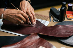 用手工工具加工天然皮革的剥皮工匠的特写镜头.
